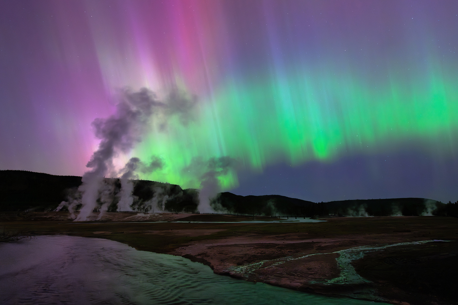 Yellowstone National Park, Wyoming A rare and powerful solar storm creates a dazzling display of aurora, dancing over the Firehole River near Biscuit Basin and painting the night sky with shades of pink and green.
