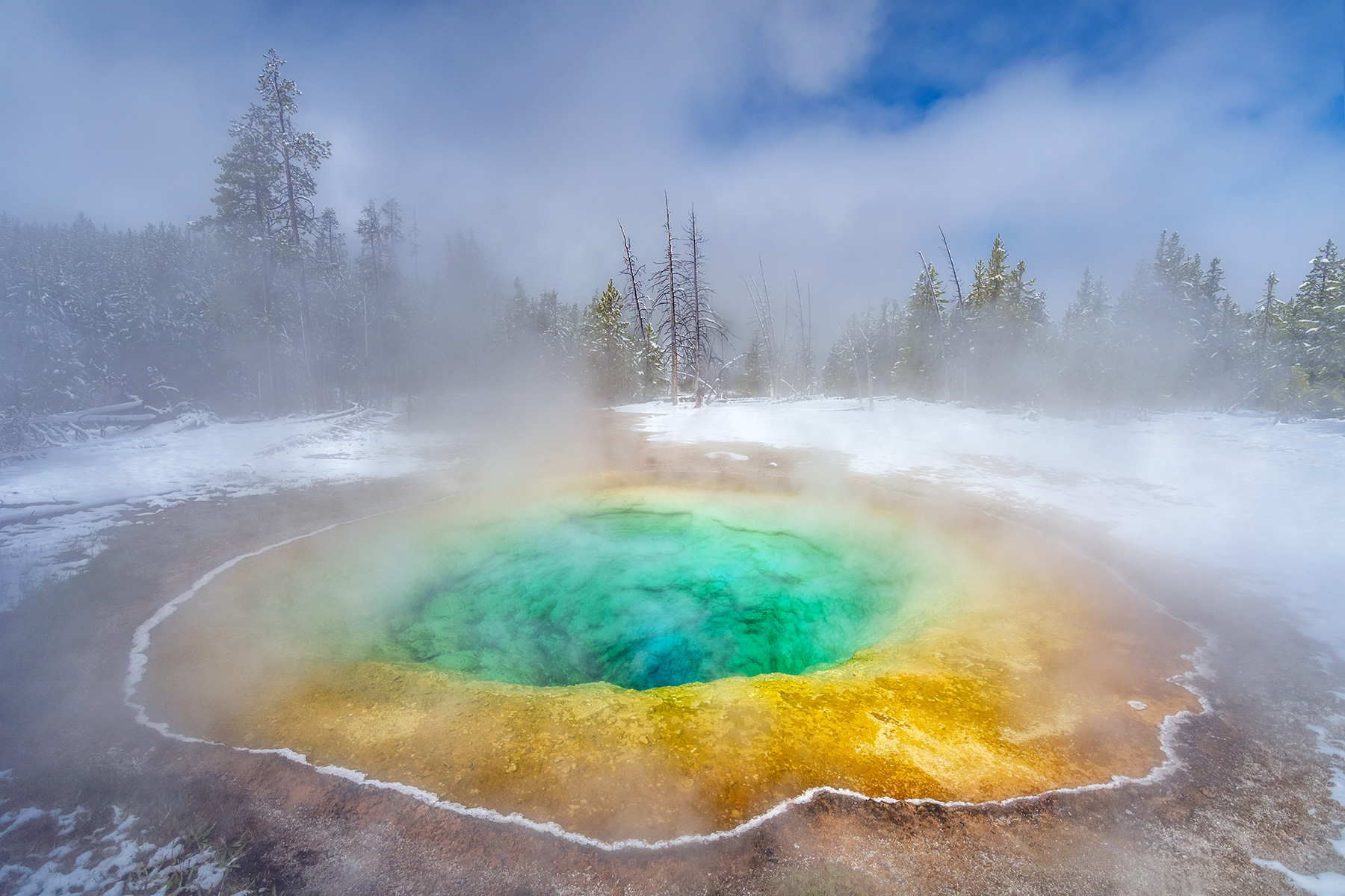 Yellowstone National Park, Wyoming A late- season snowstorm blankets the surrounding landscape of the famous Morning Glory Pool in the Upper Geyser Basin.